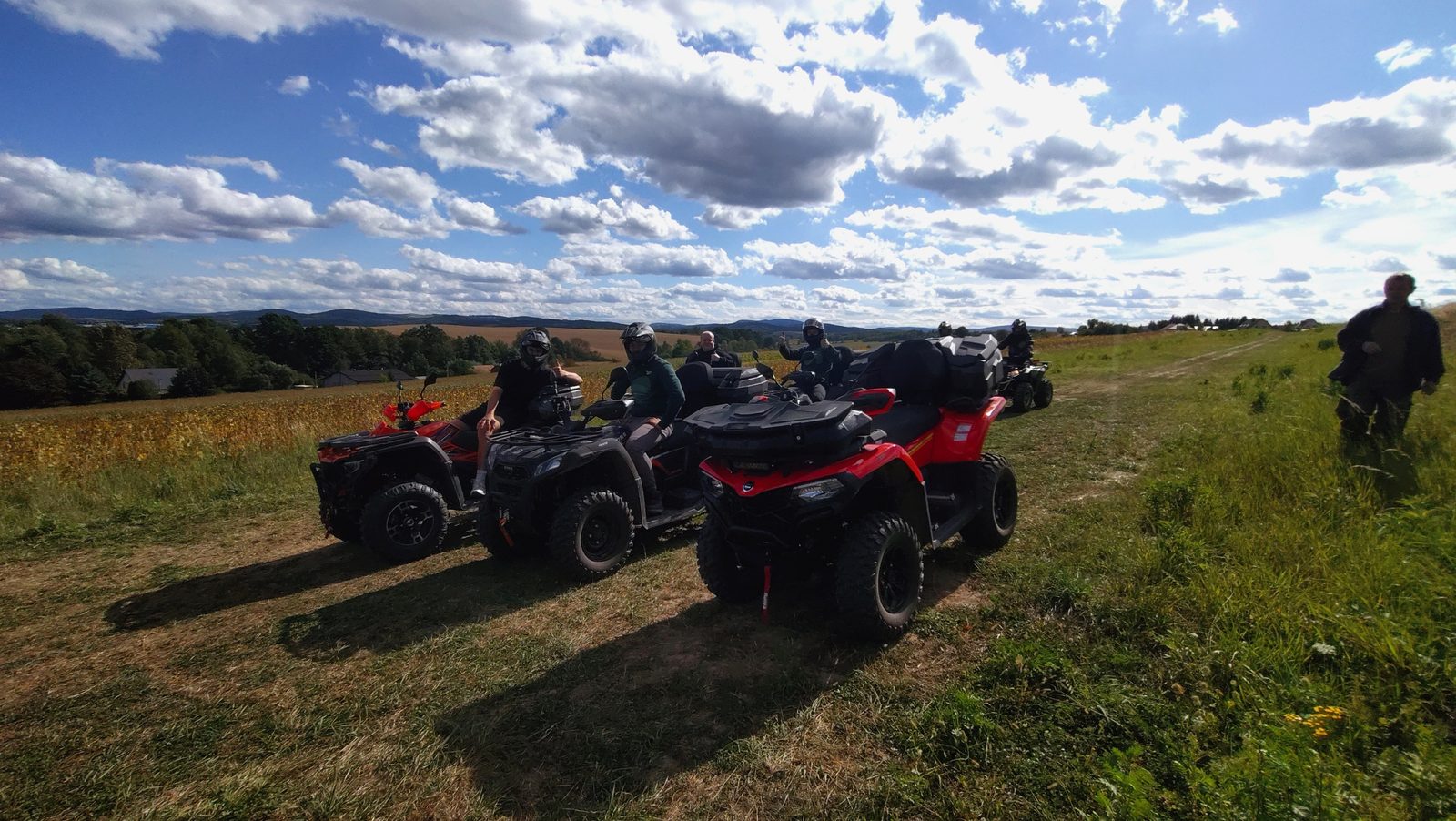 Uczestnicy wyprawy na quadach 4×4 na łące z widokiem na góry
